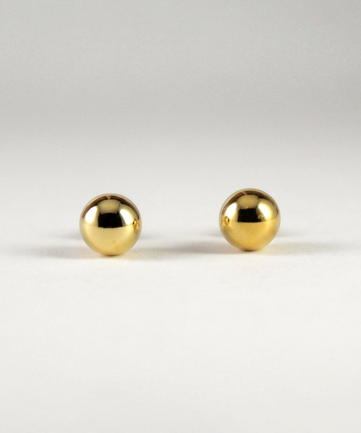 ROLE STOREのLosauボールピアス。直径8mmの光沢あるゴールド仕上げの球体デザインで、シンプルで洗練されたシルバー925製。