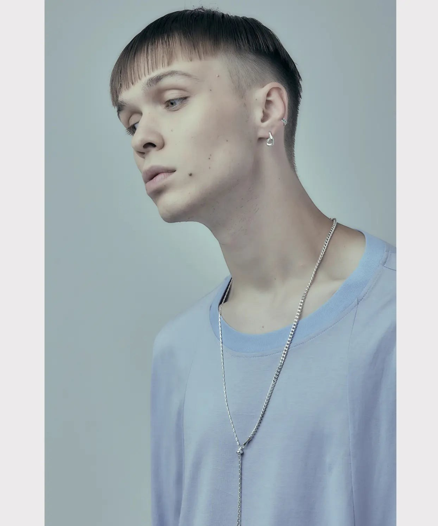 ROLE STOREのNOISE NECKLACE。2種類のシルバー925チェーンを組み合わせた、調整可能なシルバーネックレスを着用したモデル。