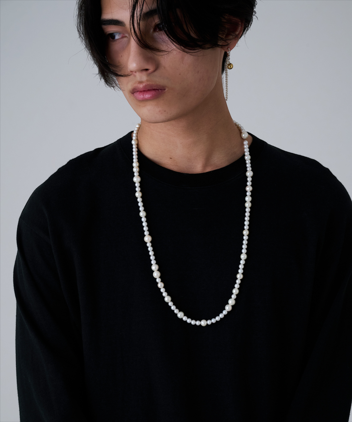 ROLE STOREのHERGO淡水パールネックレス。大小のパールを組み合わせたシルバー925製のロングネックレスを着用した男性。