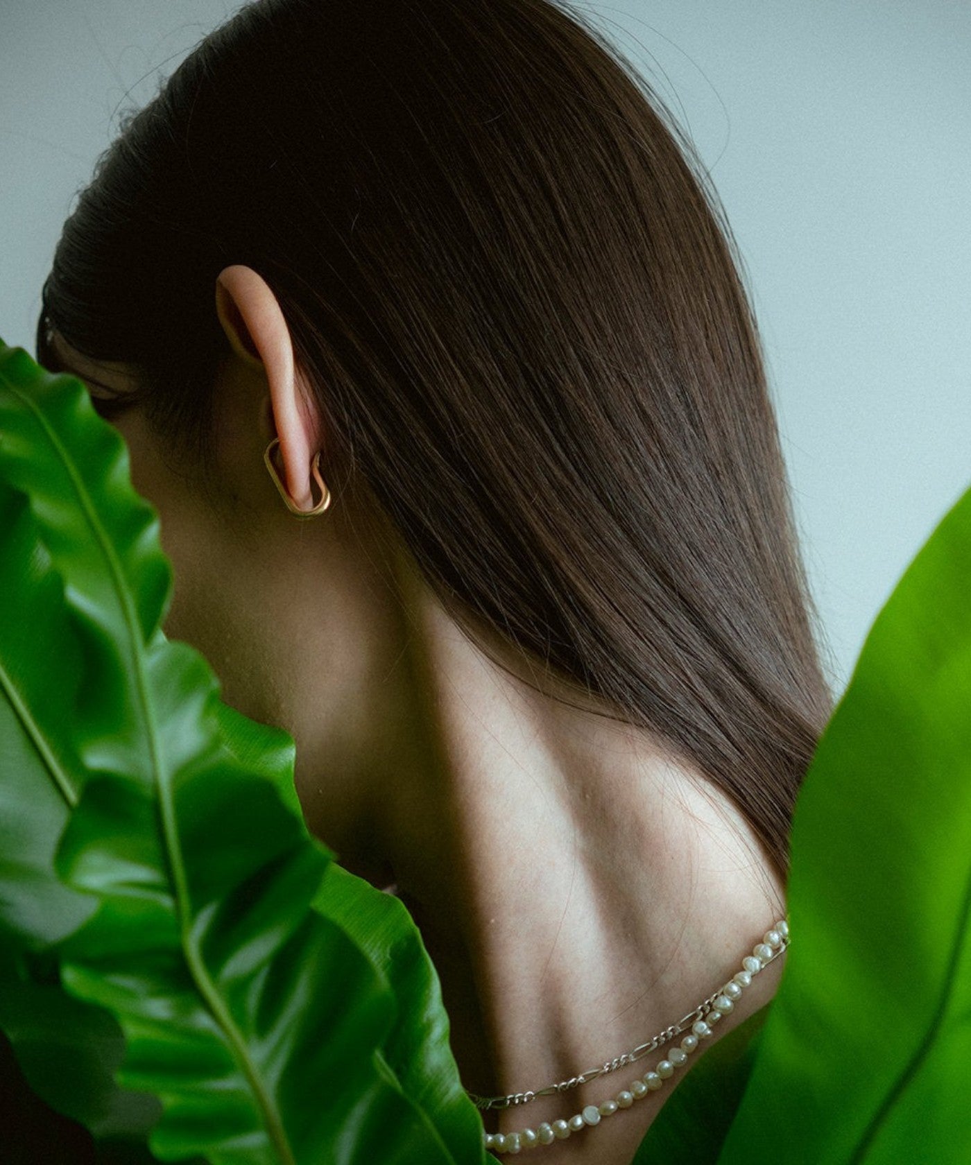 ROLE STOREのOblong earcuff。ゴールドカラーの長円型イヤーカフを着用した女性の横顔。